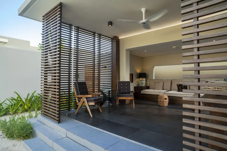 Covered terrace with lounge chairs outside a Private Pool Pavilion Villa at Nizuc Resort and Spa.