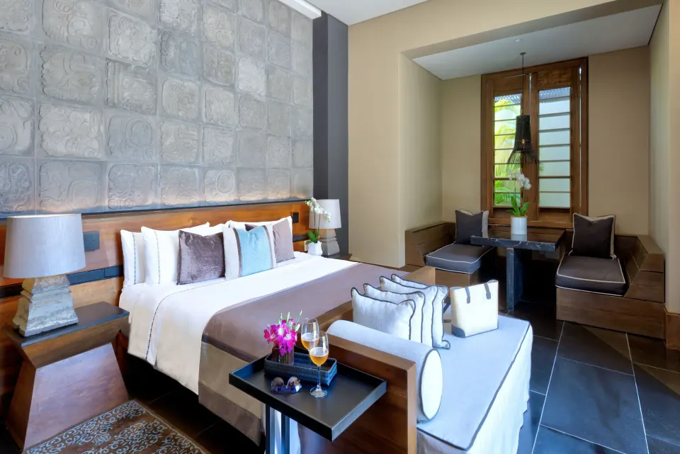 Private Pool Pavilion Villa king bedroom with sofa and dining nook at Nizuc Resort and Spa.