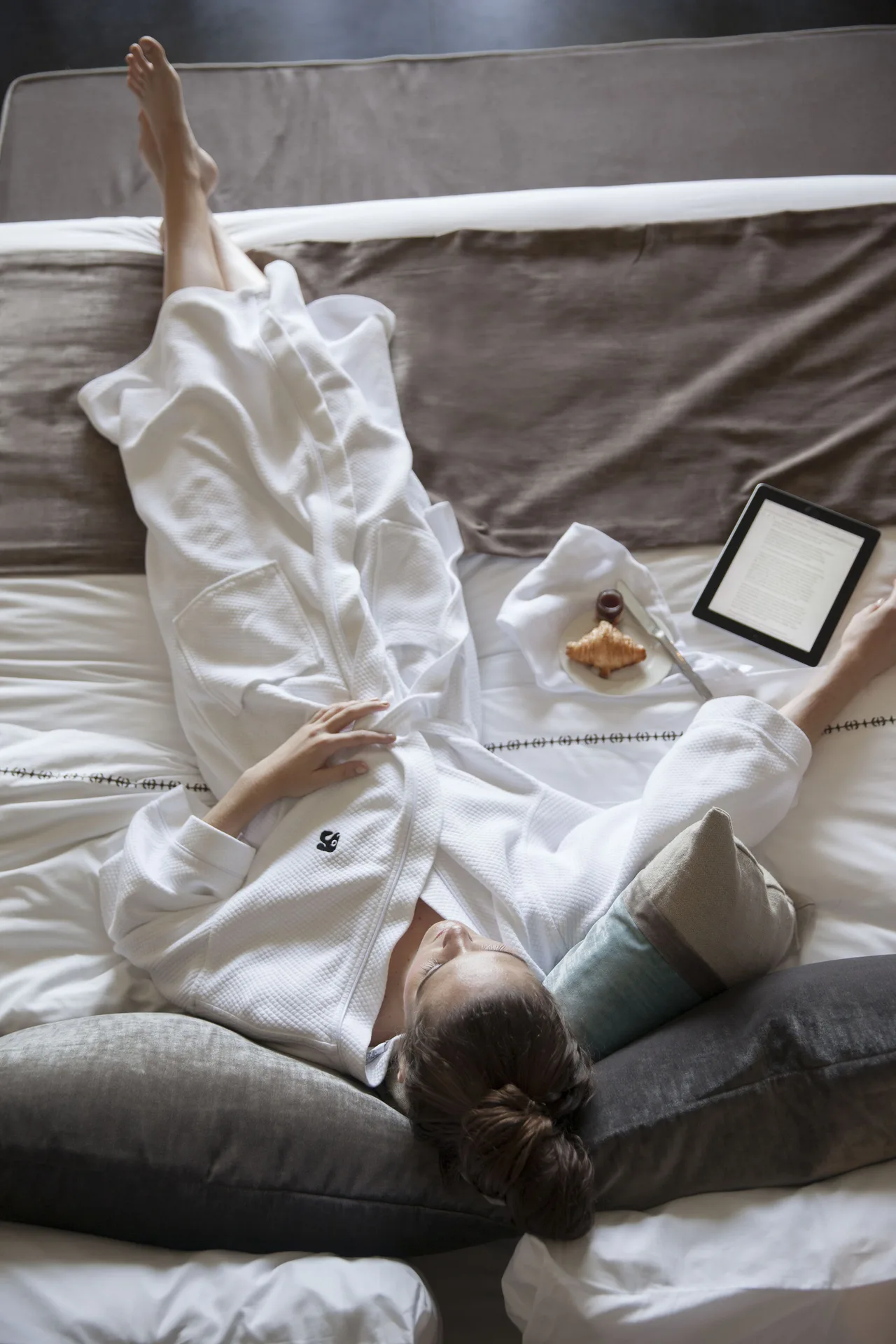 Guest relaxing in a robe on a garden view room bed at Nizuc Resort and Spa.