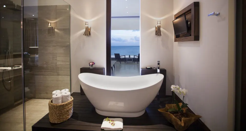 Master Suite bathroom at Nizuc Resort and Spa with freestanding tub and ocean view beyond.