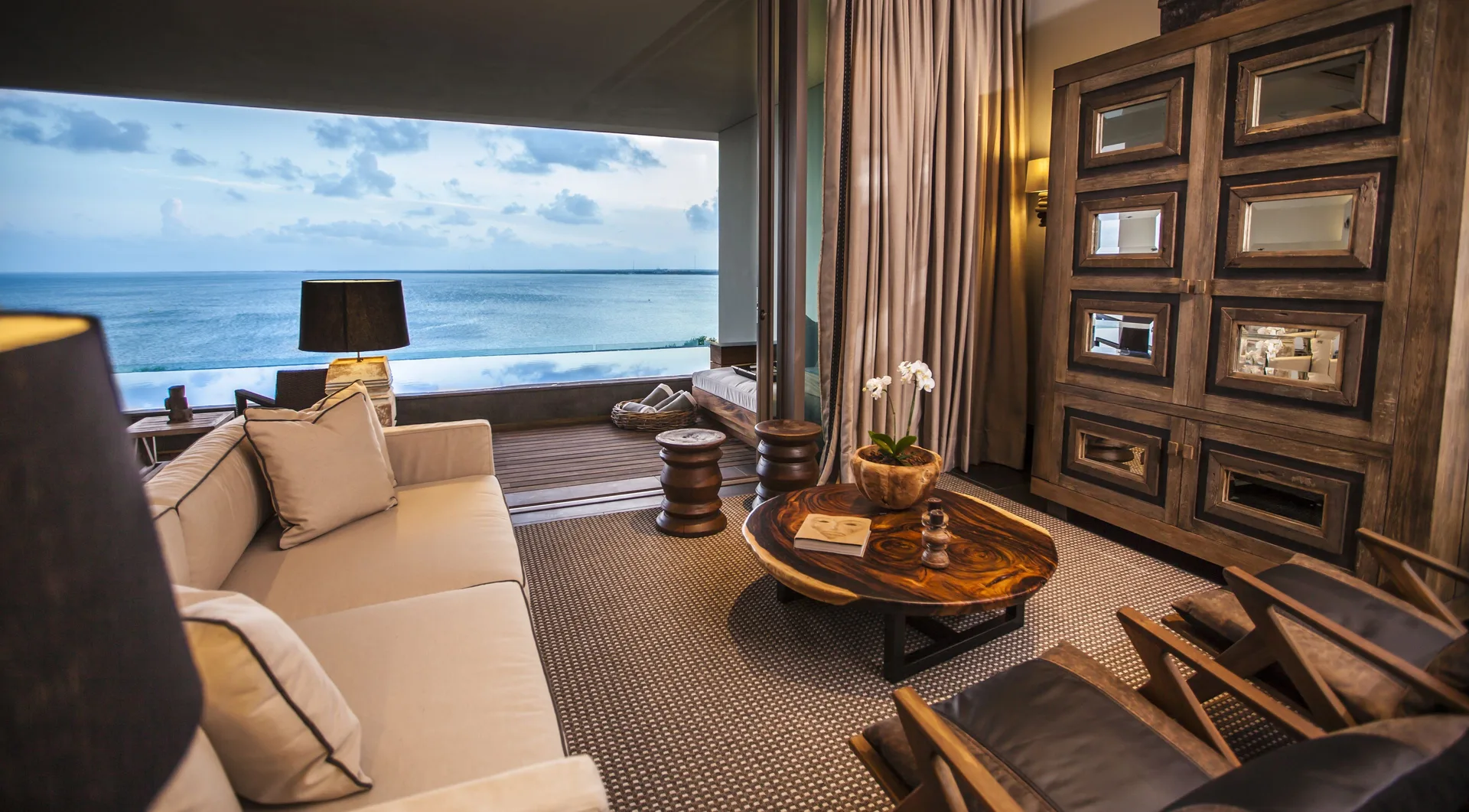 Master Suite living room at Nizuc Resort and Spa with sofa, wood furnishings and ocean view.
