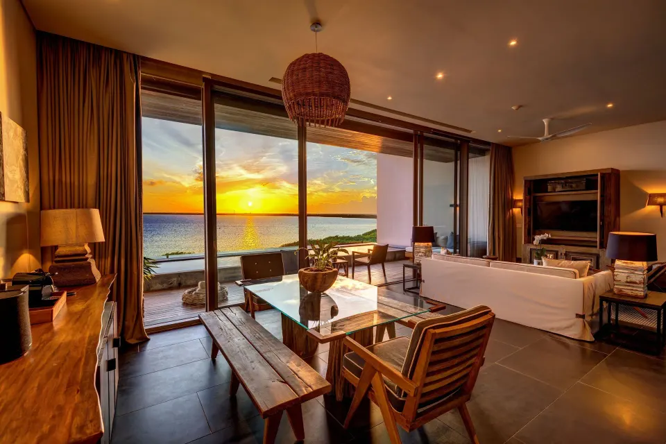 Master Suite living room at Nizuc Resort and Spa with sunset view through glass doors.