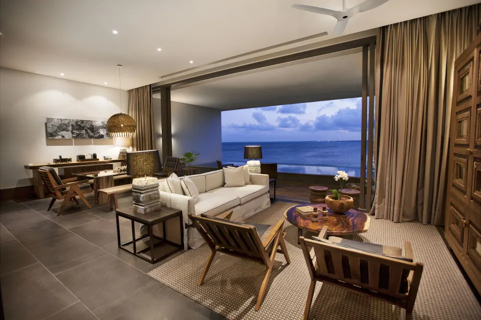 Master Suite lounge at Nizuc Resort and Spa with seating area, desk and ocean-facing terrace.