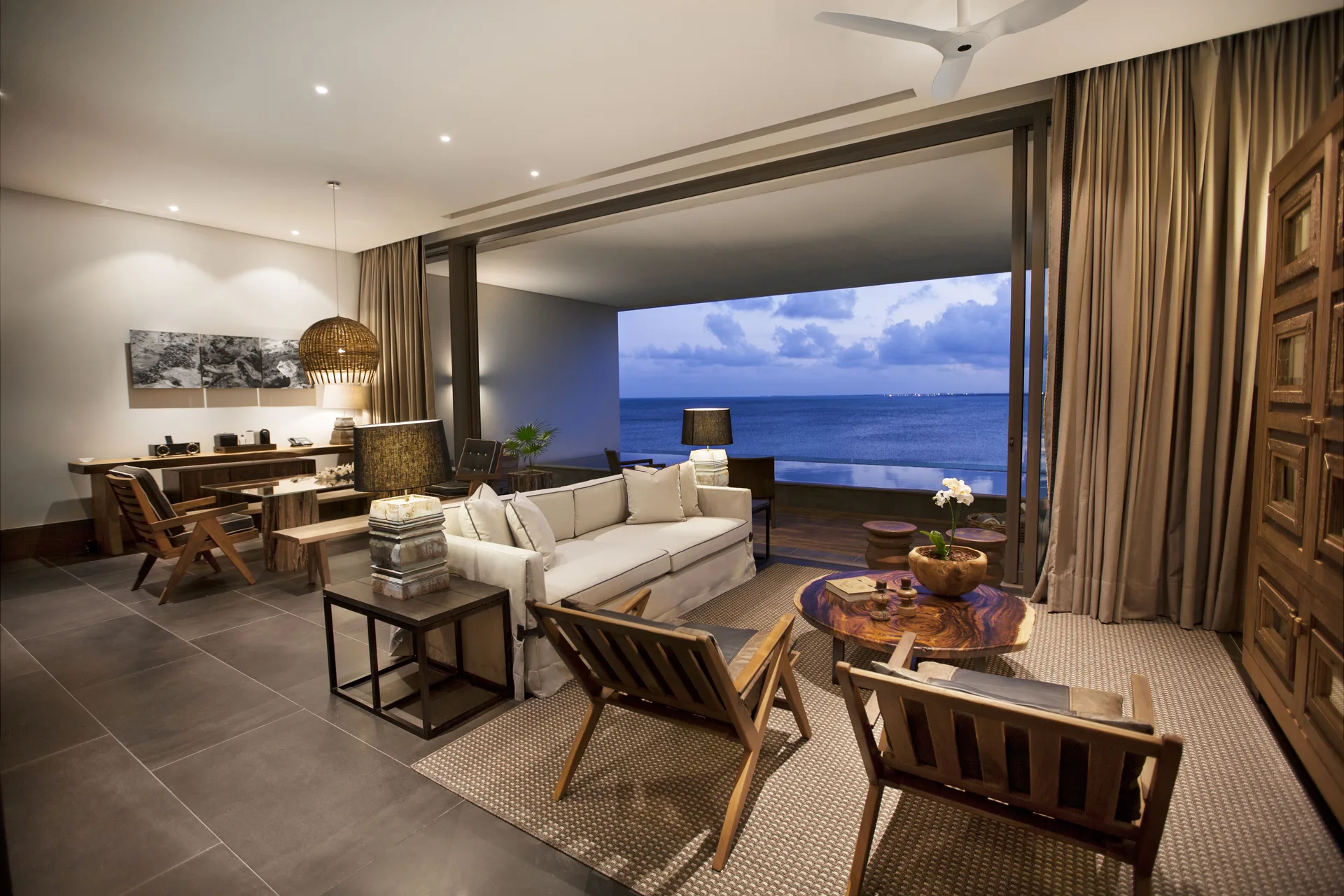 Master Suite lounge at Nizuc Resort and Spa with seating area, desk and ocean-facing terrace.