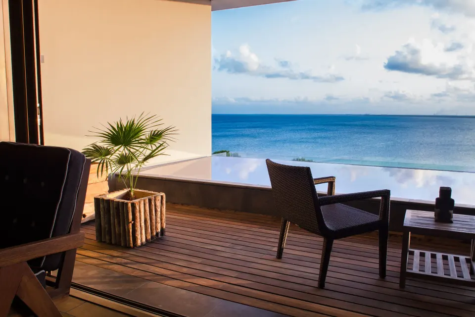Master Suite terrace seating at Nizuc Resort and Spa with potted palm and ocean view.
