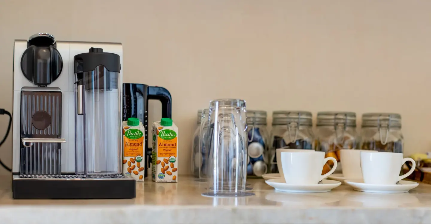 Coffee maker with cups, glasses and stocked jars in a guest room at Nobu Hotel Los Cabos.
