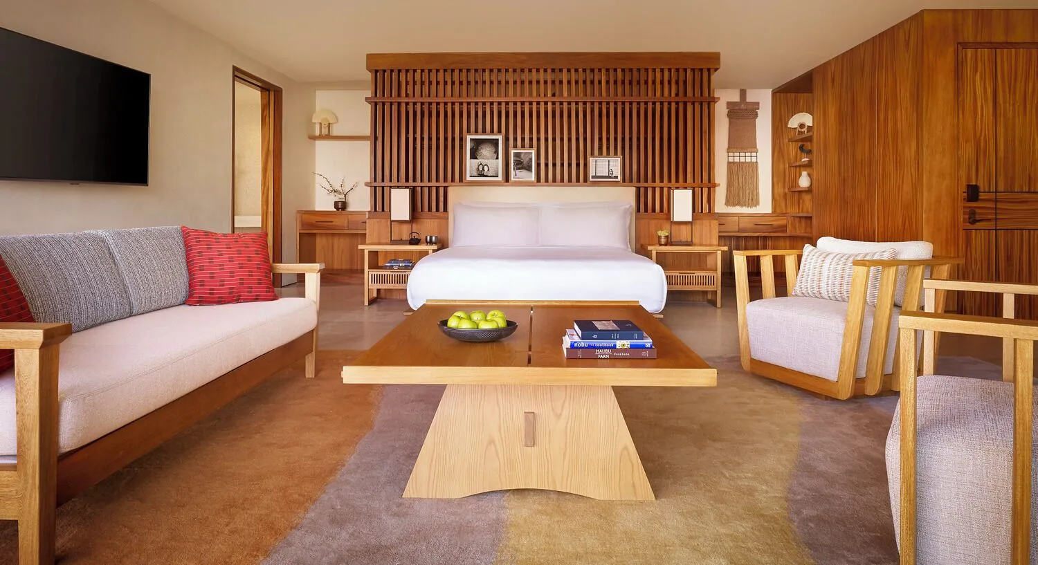 Guest room with king bed, sofa seating and central coffee table at Nobu Hotel Los Cabos.