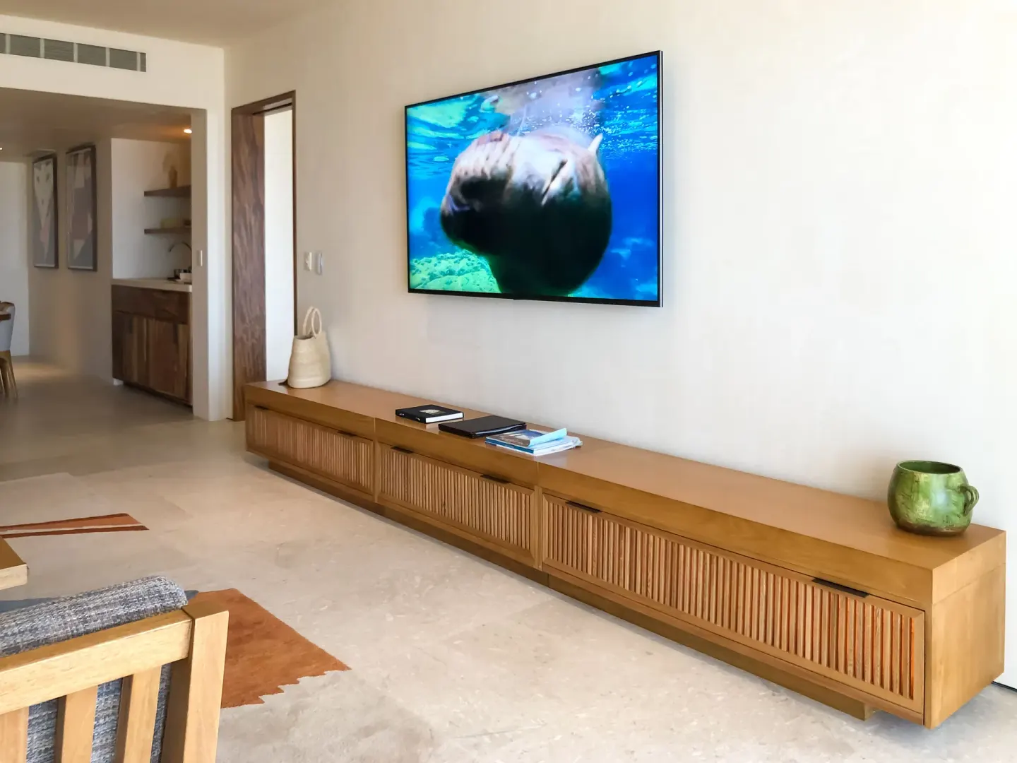 Guest room media wall with television and long wood console at Nobu Hotel Los Cabos.
