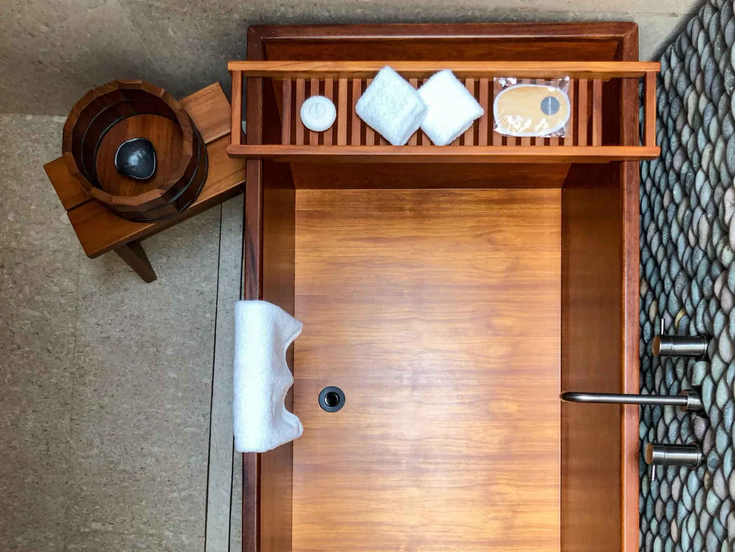 Wooden soaking tub with towels and bath items at Nobu Hotel Los Cabos.
