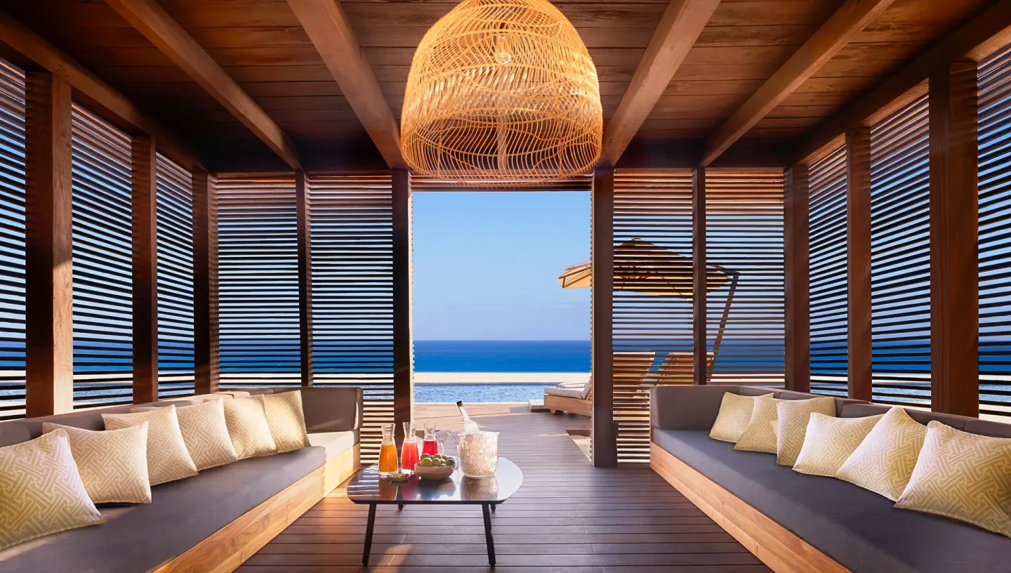 Oceanfront cabana lounge with sofas and pool view at Nobu Hotel Los Cabos.