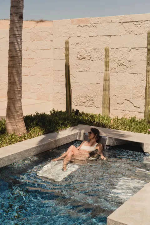 A guest relaxes in a small outdoor spa pool at Nobu Hotel Los Cabos.