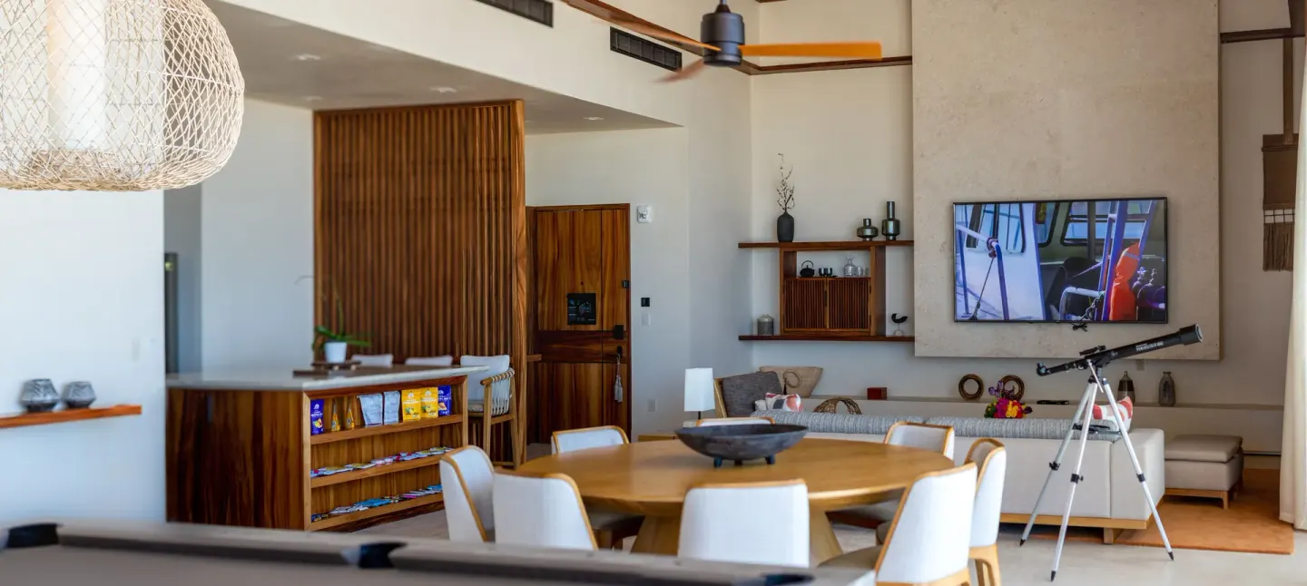 Suite dining and lounge area with round table and telescope at Nobu Hotel Los Cabos.