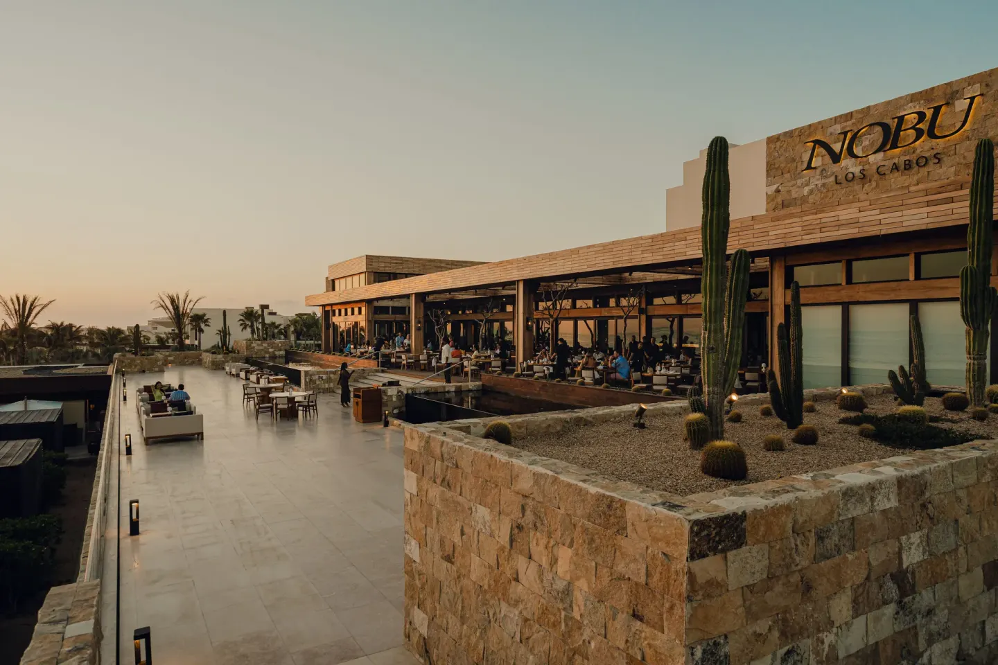 Nobu Hotel Los Cabos restaurant terrace and walkway at sunset at Nobu Hotel Los Cabos.
