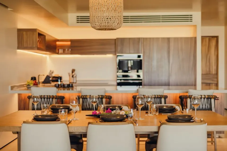Dining table set before the kitchen in an Asahi residence at Nobu Hotel Los Cabos.