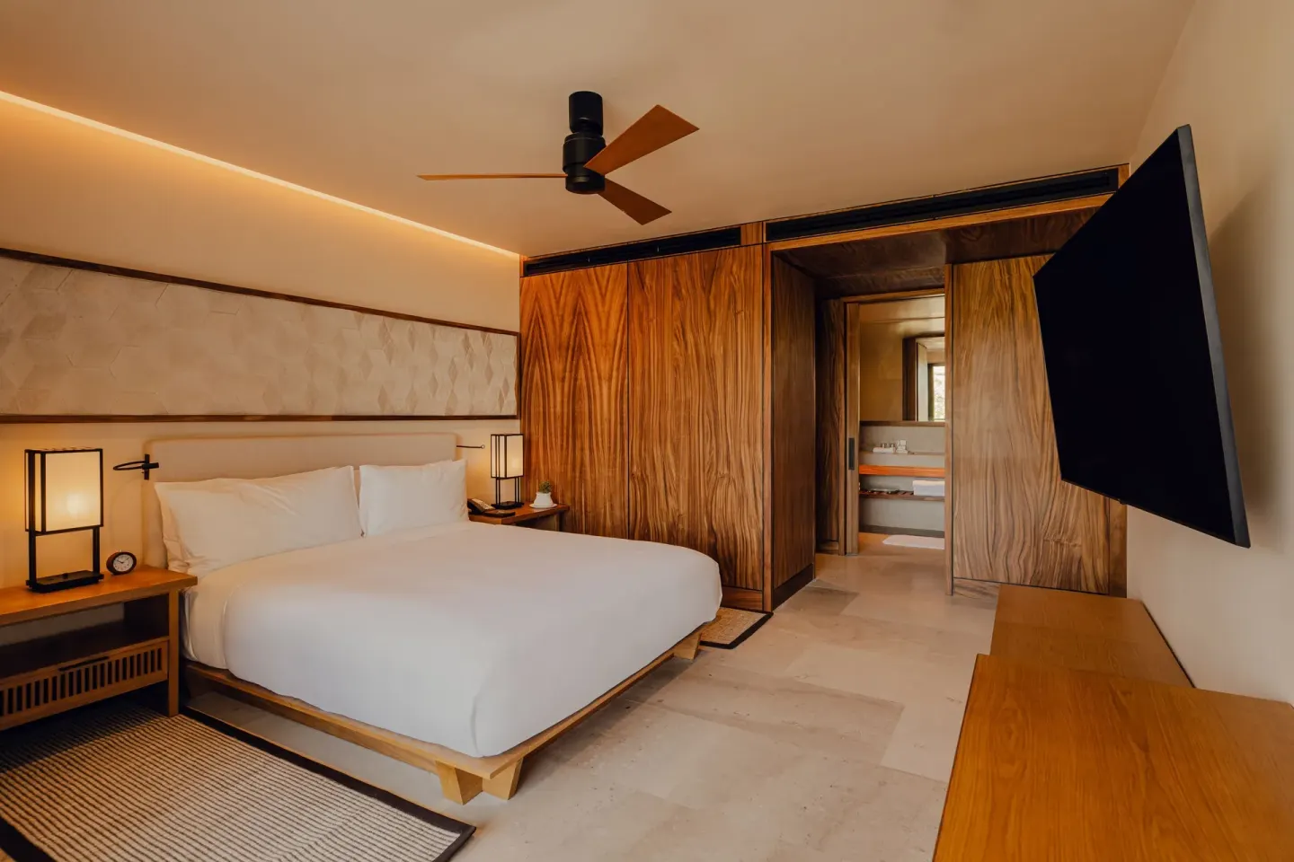 King bedroom with TV and bathroom entry in an Asahi residence at Nobu Hotel Los Cabos.