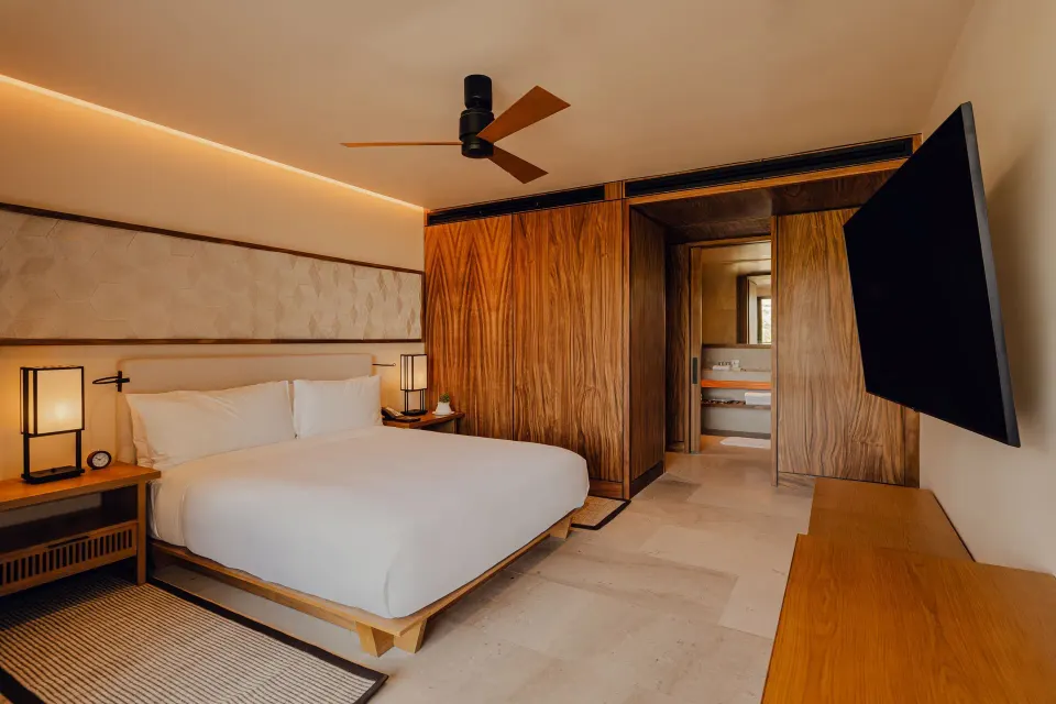 King bedroom with TV and bathroom entry in an Asahi residence at Nobu Hotel Los Cabos.
