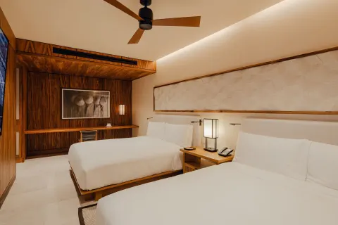 Two-bed guest room with wood desk wall in an Asahi residence at Nobu Hotel Los Cabos.