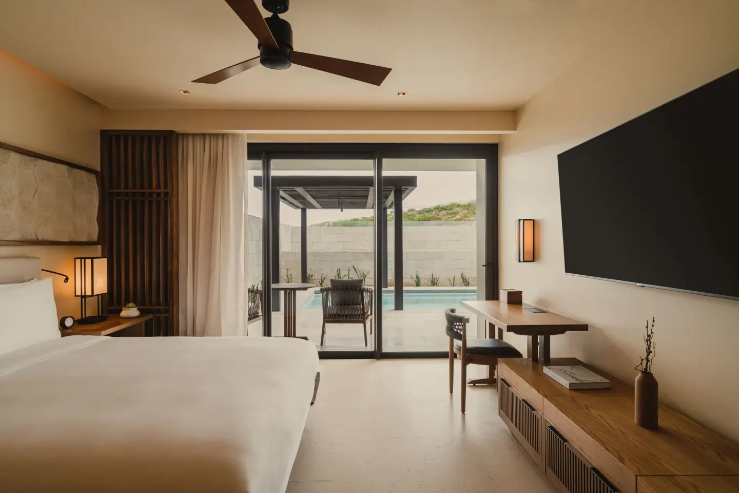 Bedroom with king bed, wall TV, and terrace pool at Nobu Hotel Los Cabos.