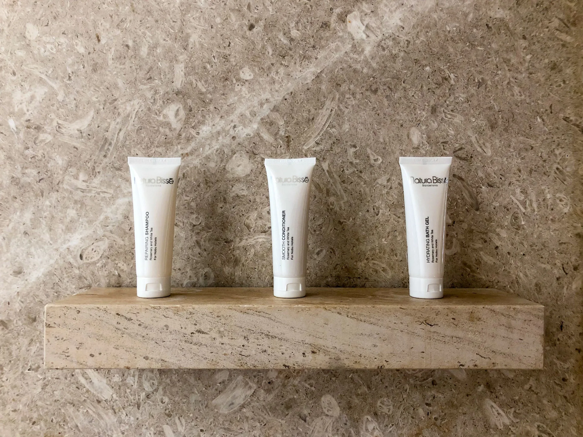 Deluxe Room bath amenities on a stone shower shelf at Nobu Hotel Los Cabos.