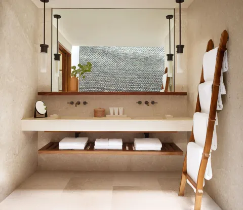 Deluxe Room bathroom vanity with mirror and towel ladder at Nobu Hotel Los Cabos.