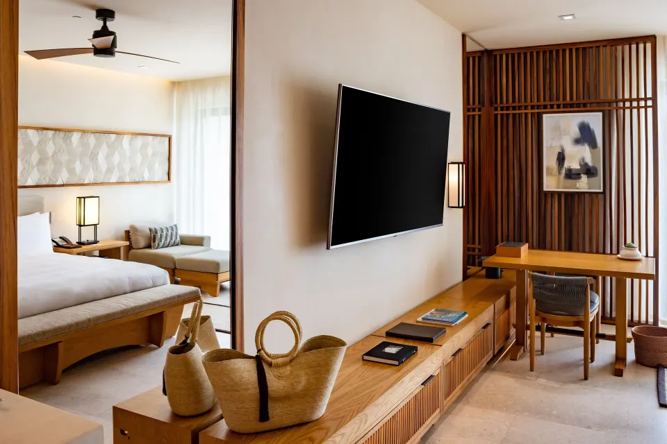 Deluxe Room media wall with desk and partial king bed view at Nobu Hotel Los Cabos.