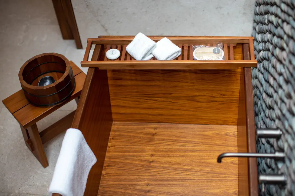 Deluxe Room soaking tub tray with towels and bath items at Nobu Hotel Los Cabos.