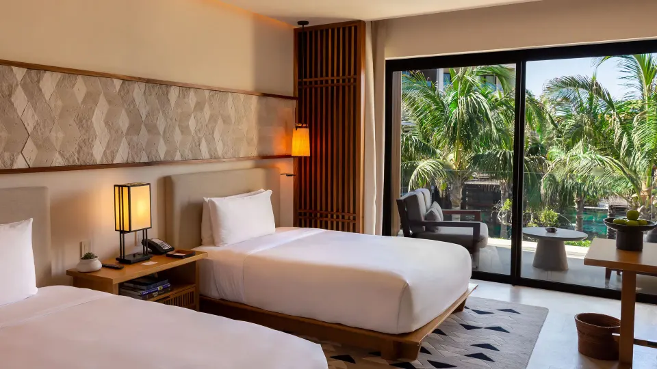Deluxe Room with two beds, balcony, and palms at Nobu Hotel Los Cabos.