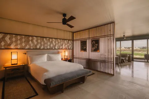 Hikari One Bedroom at Nobu Hotel Los Cabos with king bed, wood screen and sitting area beyond.