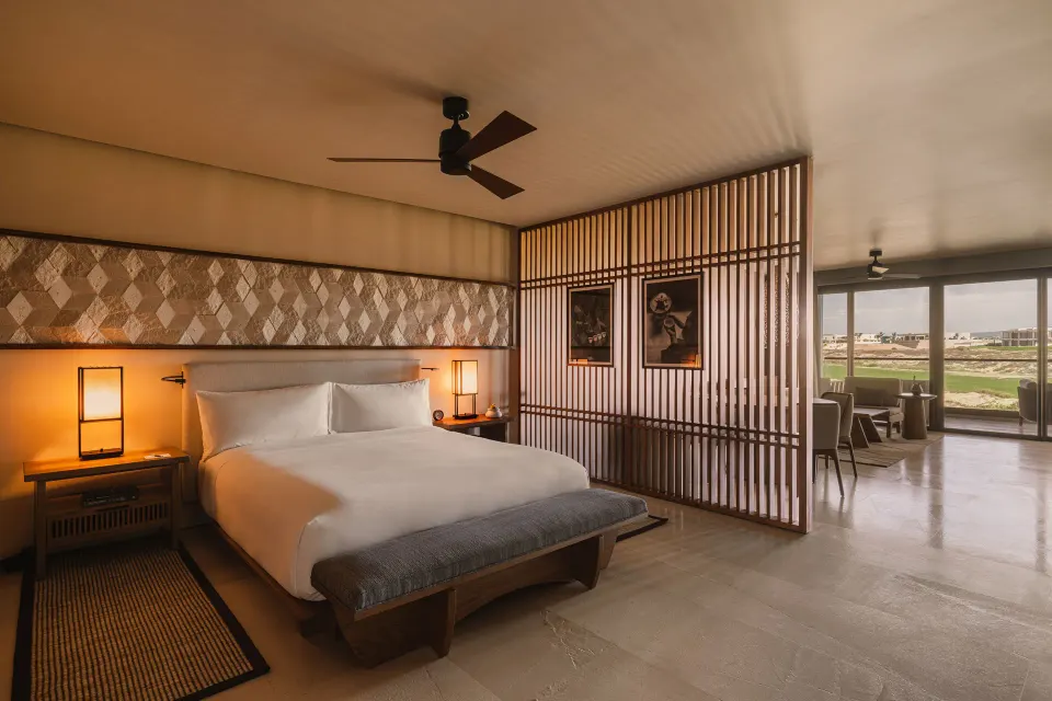 Hikari One Bedroom at Nobu Hotel Los Cabos with king bed, wood screen and sitting area beyond.