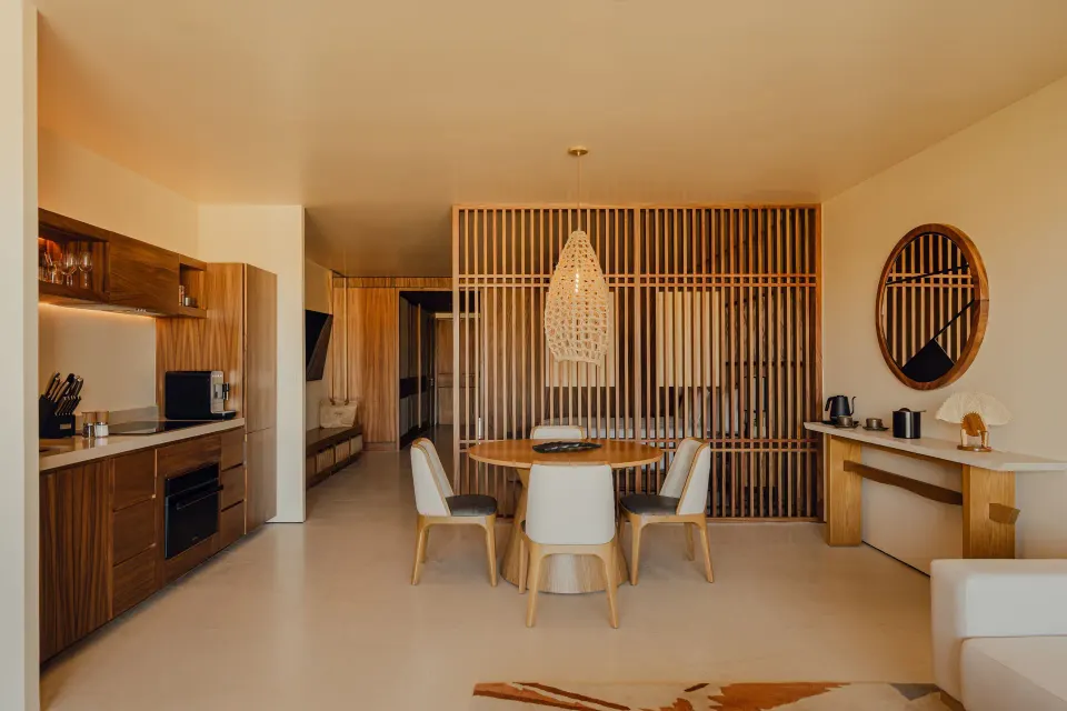 Hikari One Bedroom at Nobu Hotel Los Cabos with kitchenette, round dining table and wood slat partition.