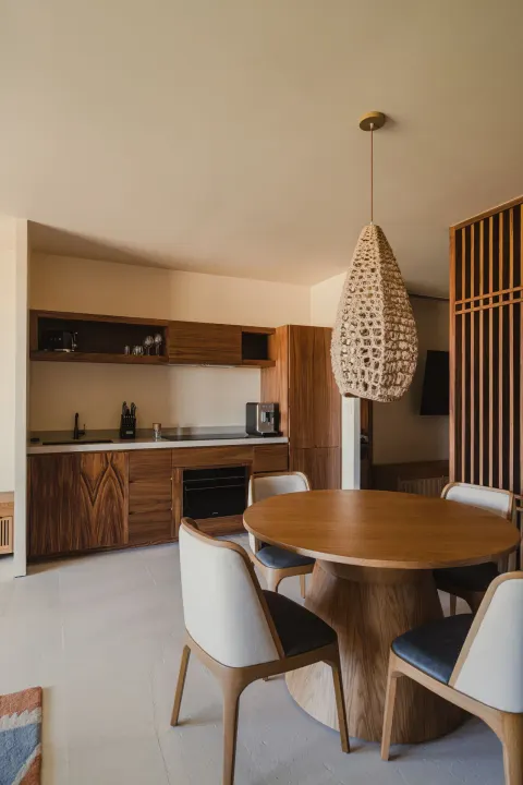 Hikari One Bedroom at Nobu Hotel Los Cabos with round dining table, pendant light and kitchenette.