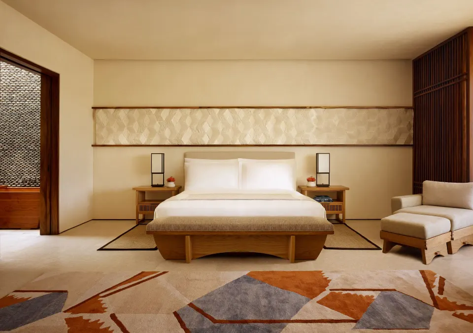 Junior Room king bed with bench and lounge chair at Nobu Hotel Los Cabos.