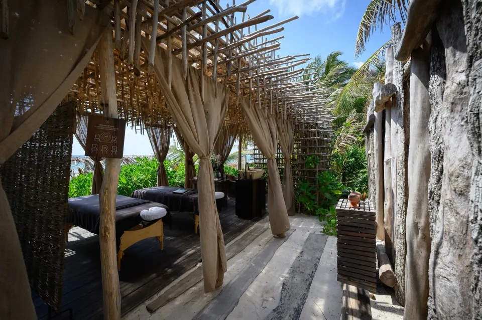 Open-sided seaside treatment area with massage tables at Nômade Temple Tulum