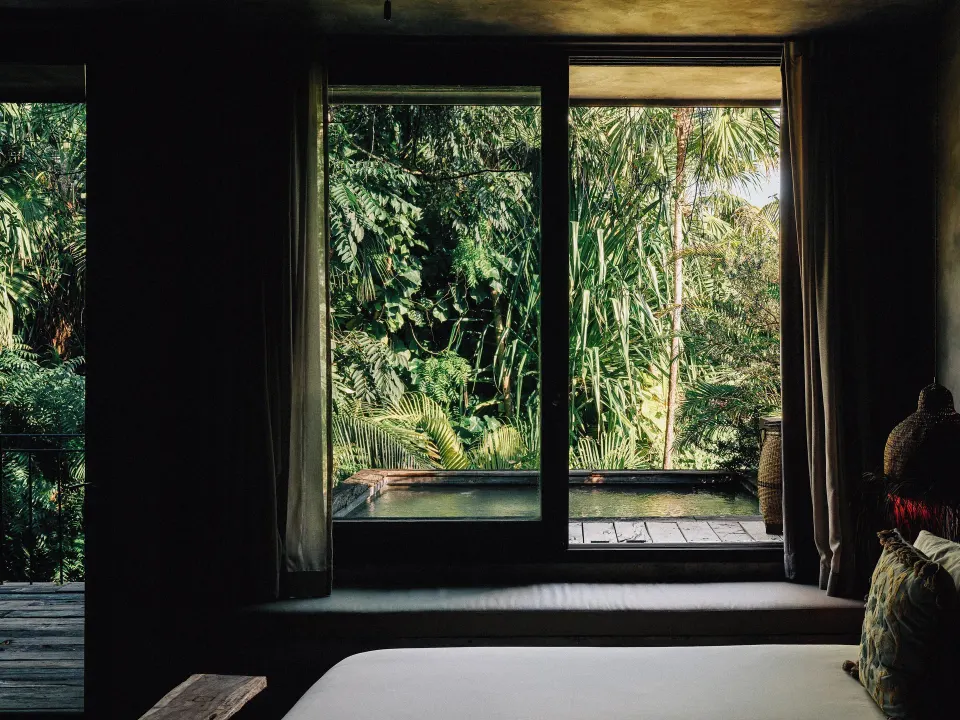 Bed corner and private plunge pool framed by jungle at Nômade Temple Tulum