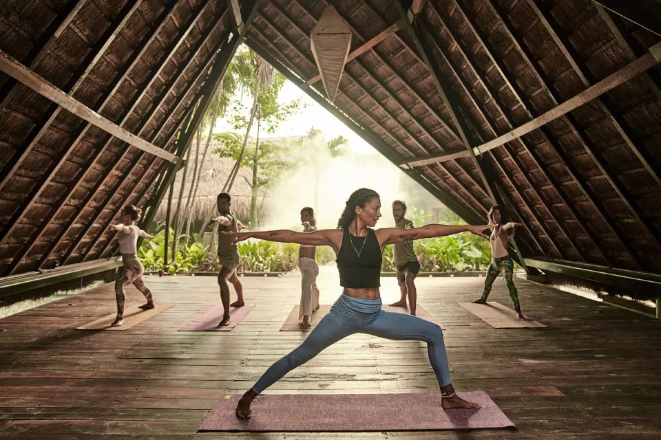 Open-air A-frame yoga pavilion with people practicing at Nômade Temple Tulum