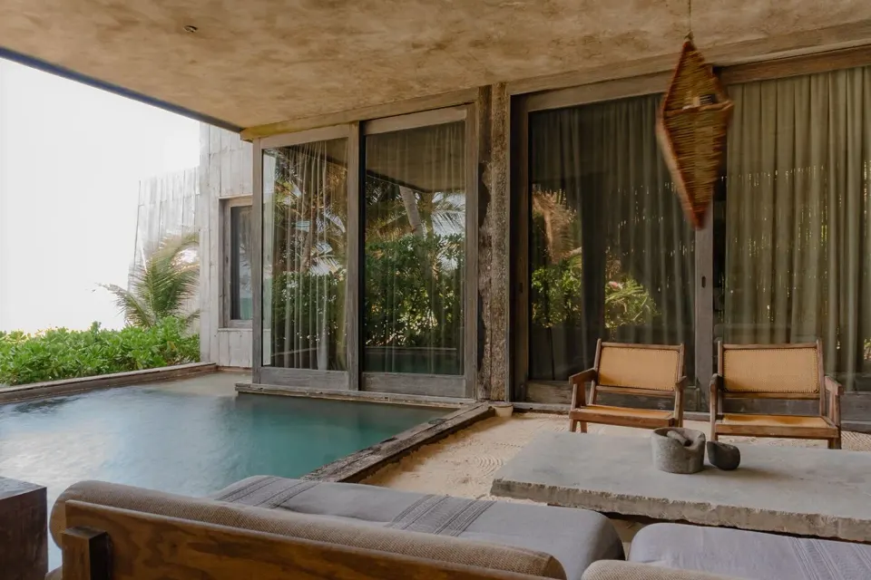 Private plunge pool and shaded terrace with lounge chairs at Nômade Temple Tulum