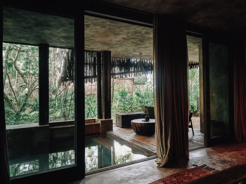 Private suite interior with indoor plunge pool and jungle view at Nômade Temple Tulum