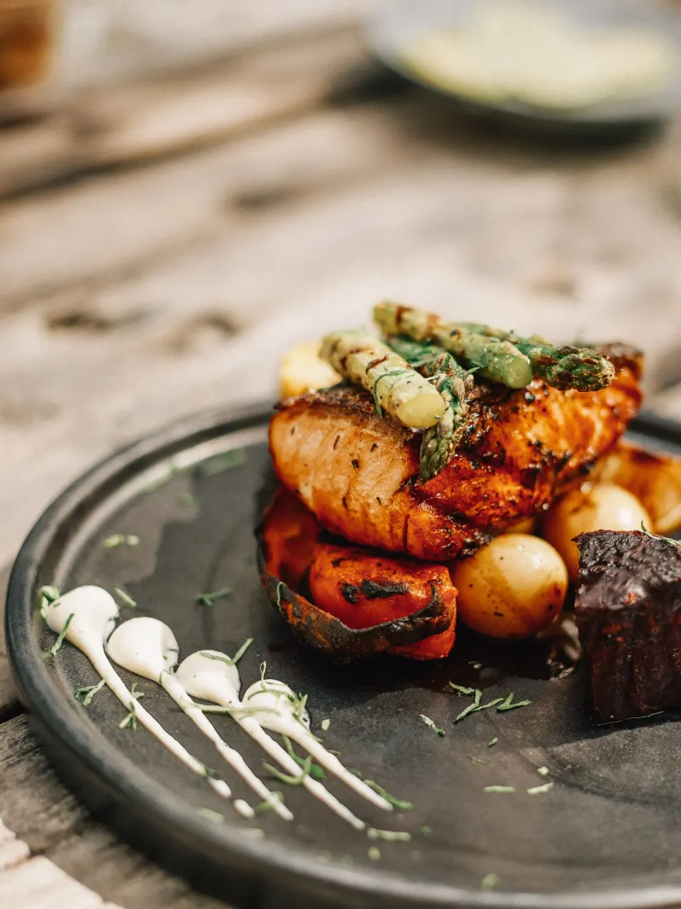 Seared fish topped with asparagus and vegetables at Nômade Temple Tulum