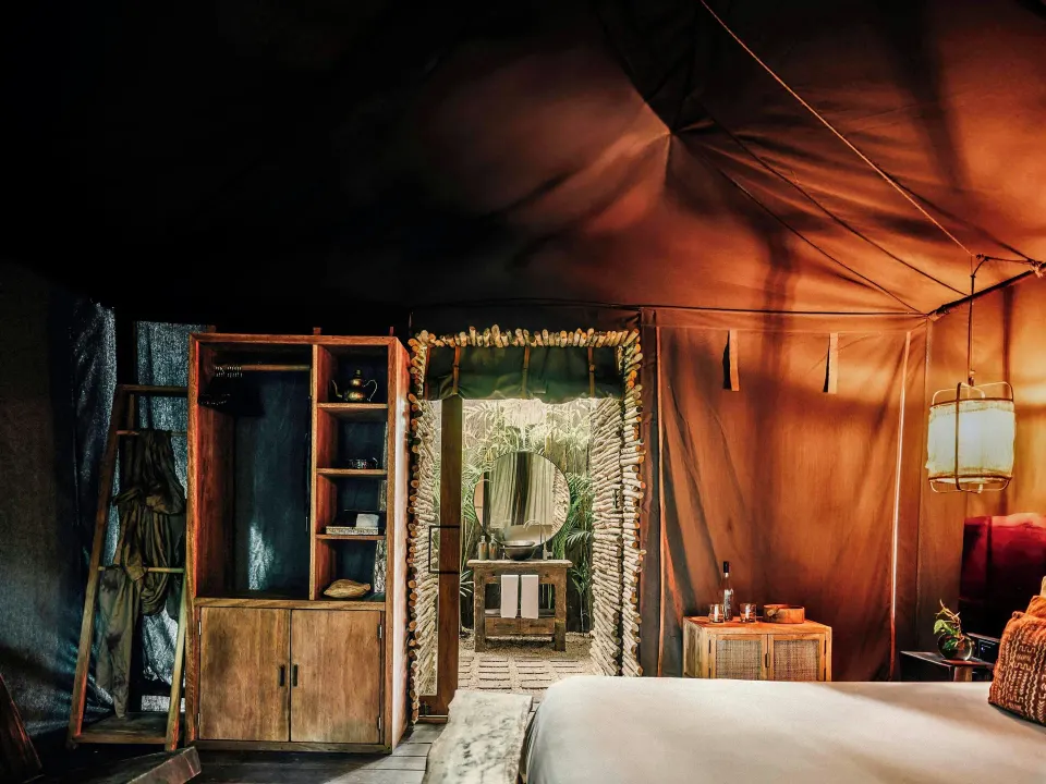 Deluxe Room garden-view bungalow interior with king bed at Nômade Temple Tulum