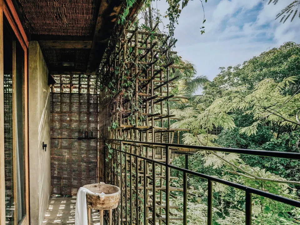 Private treehouse balcony with rustic sink and jungle view at Nômade Temple Tulum