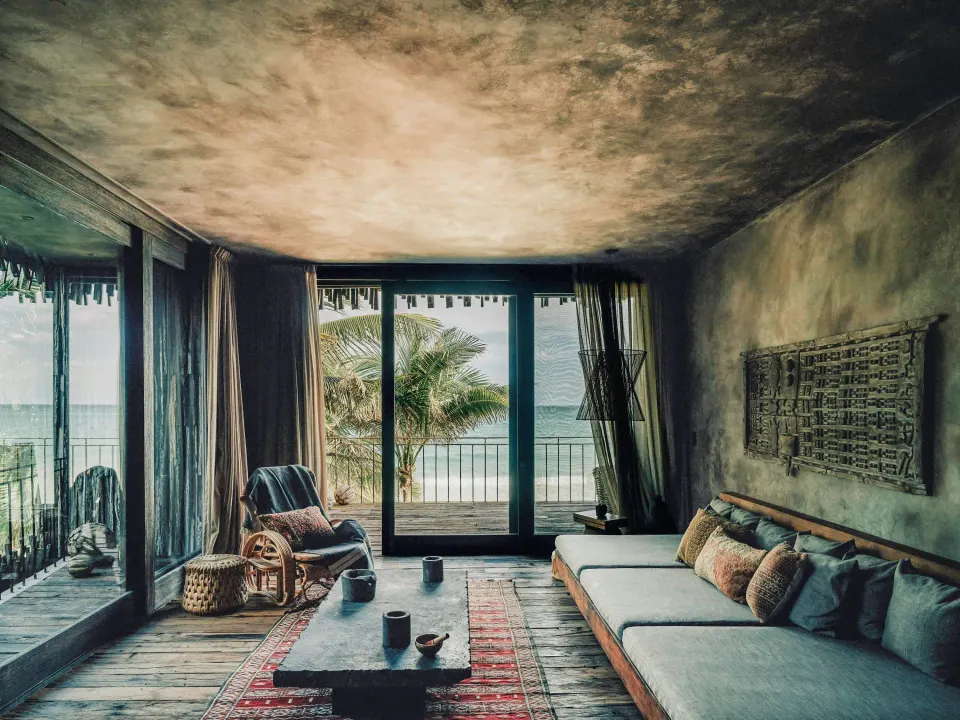 Seating area and balcony with ocean view in a Deluxe Room at Nômade Temple Tulum