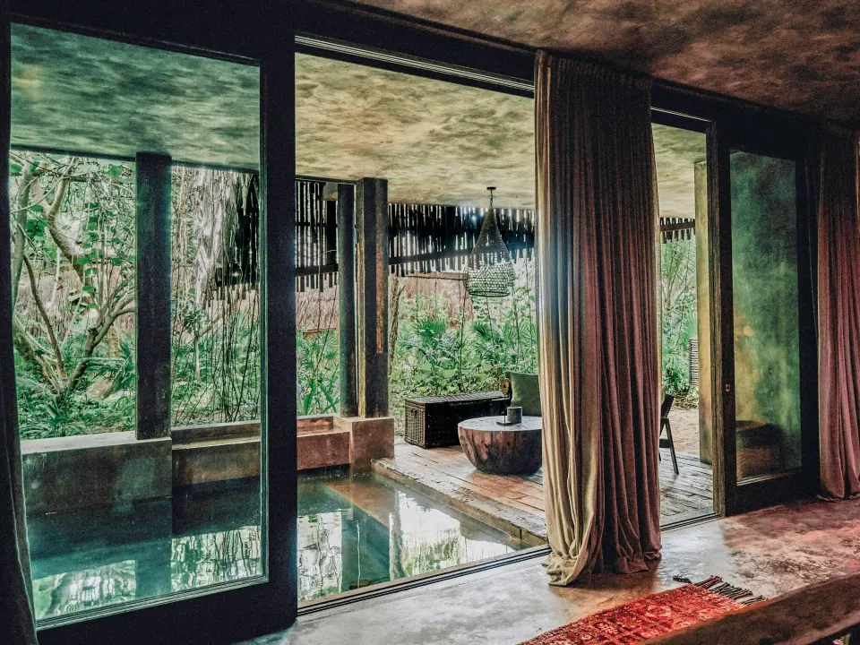 Terrace and plunge pool framed by sliding glass doors at Nômade Temple Tulum