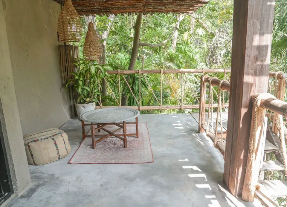 Private balcony with low table and woven accents at Nômade Temple Tulum