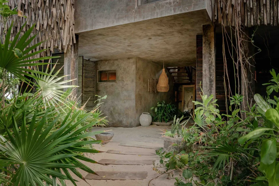 Exterior entrance and landscaped path leading to a Suite Ocean View at Nômade Temple Tulum.