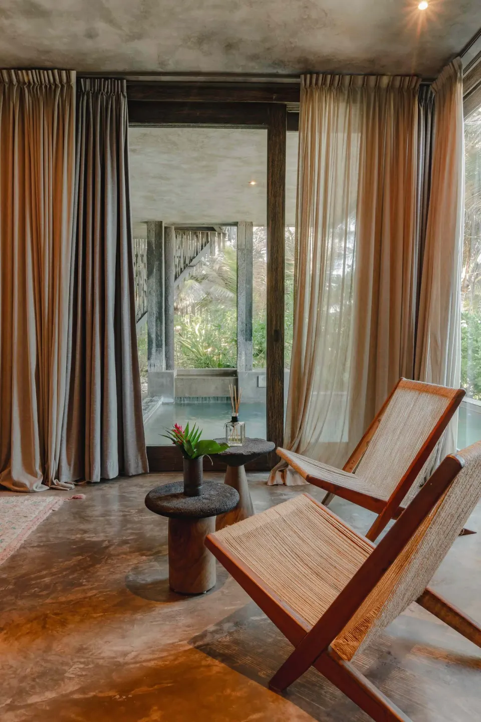 Window seating and pair of woven chairs inside a Suite, Ocean View at Nômade Temple Tulum.