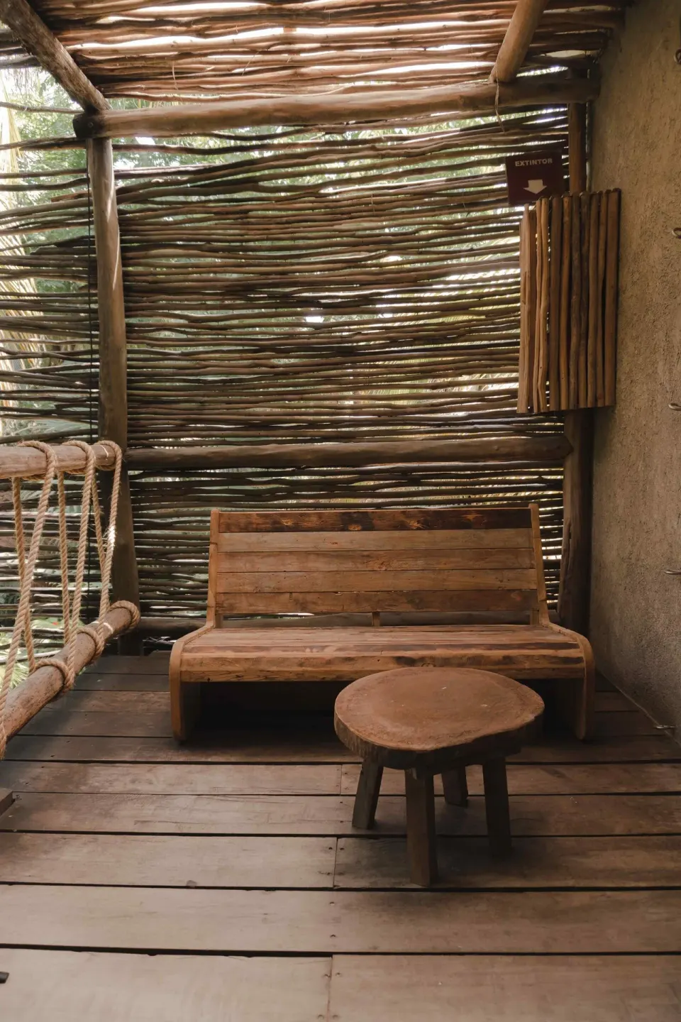 Wooden seating area on a private deck of a Superior Room Beach View at Nômade Temple Tulum