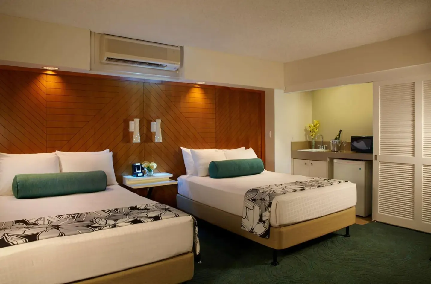 Guest room with two beds and a kitchenette area at Oasis Hotel Waikiki.