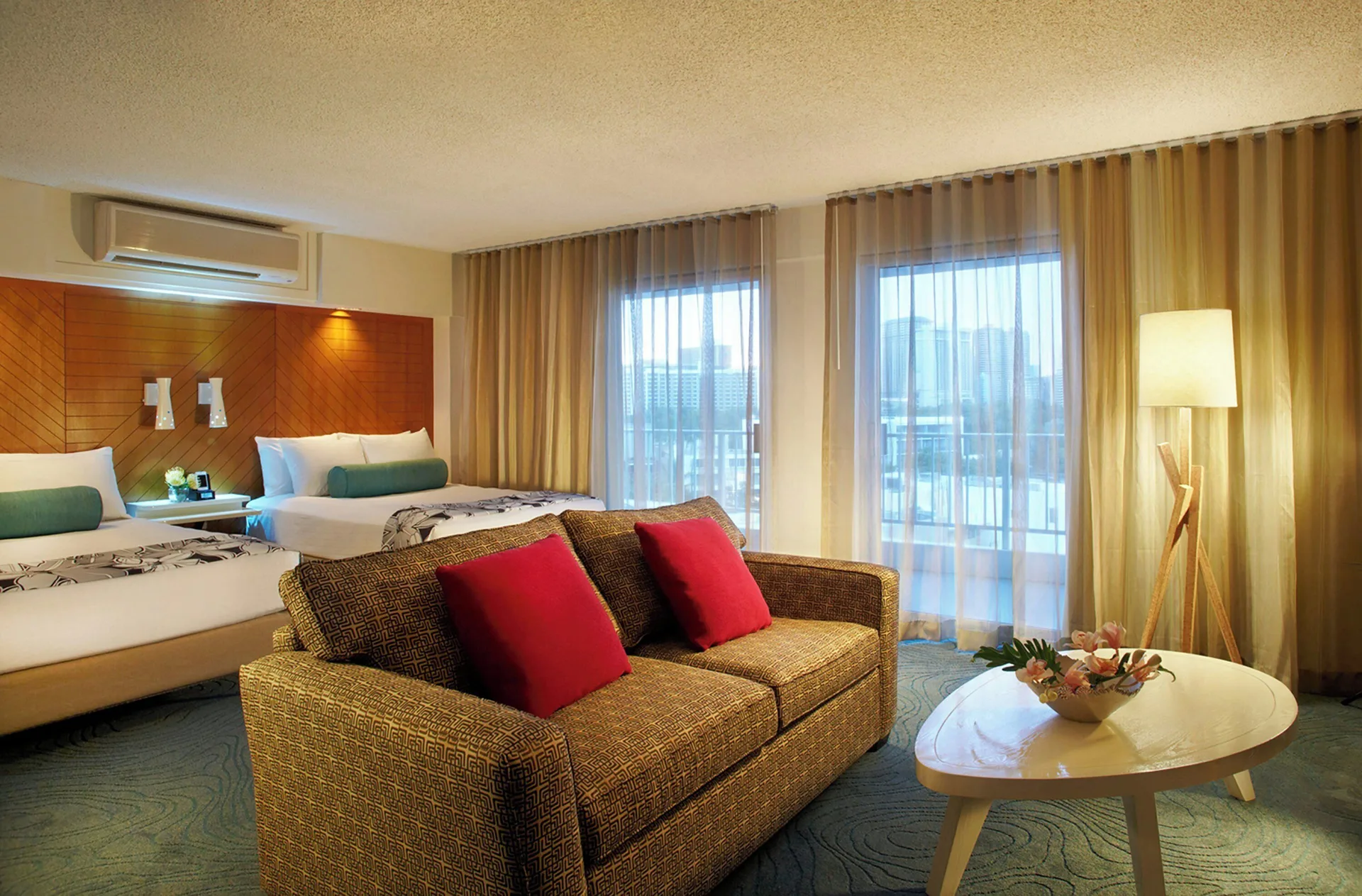 Junior Suite with multiple beds and sitting area at Oasis Hotel Waikiki.