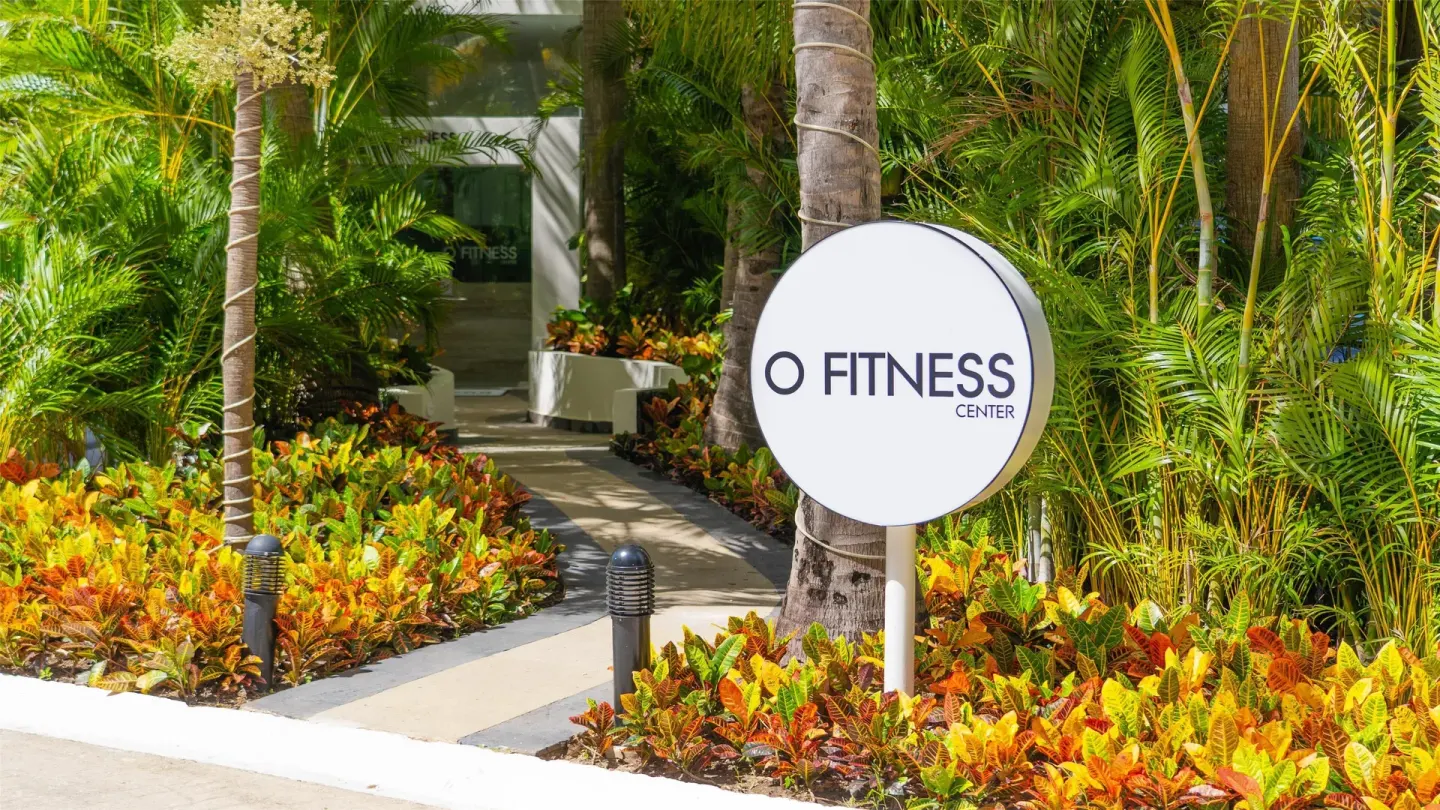 Fitness center entrance sign among tropical plants at Oasis Palm.