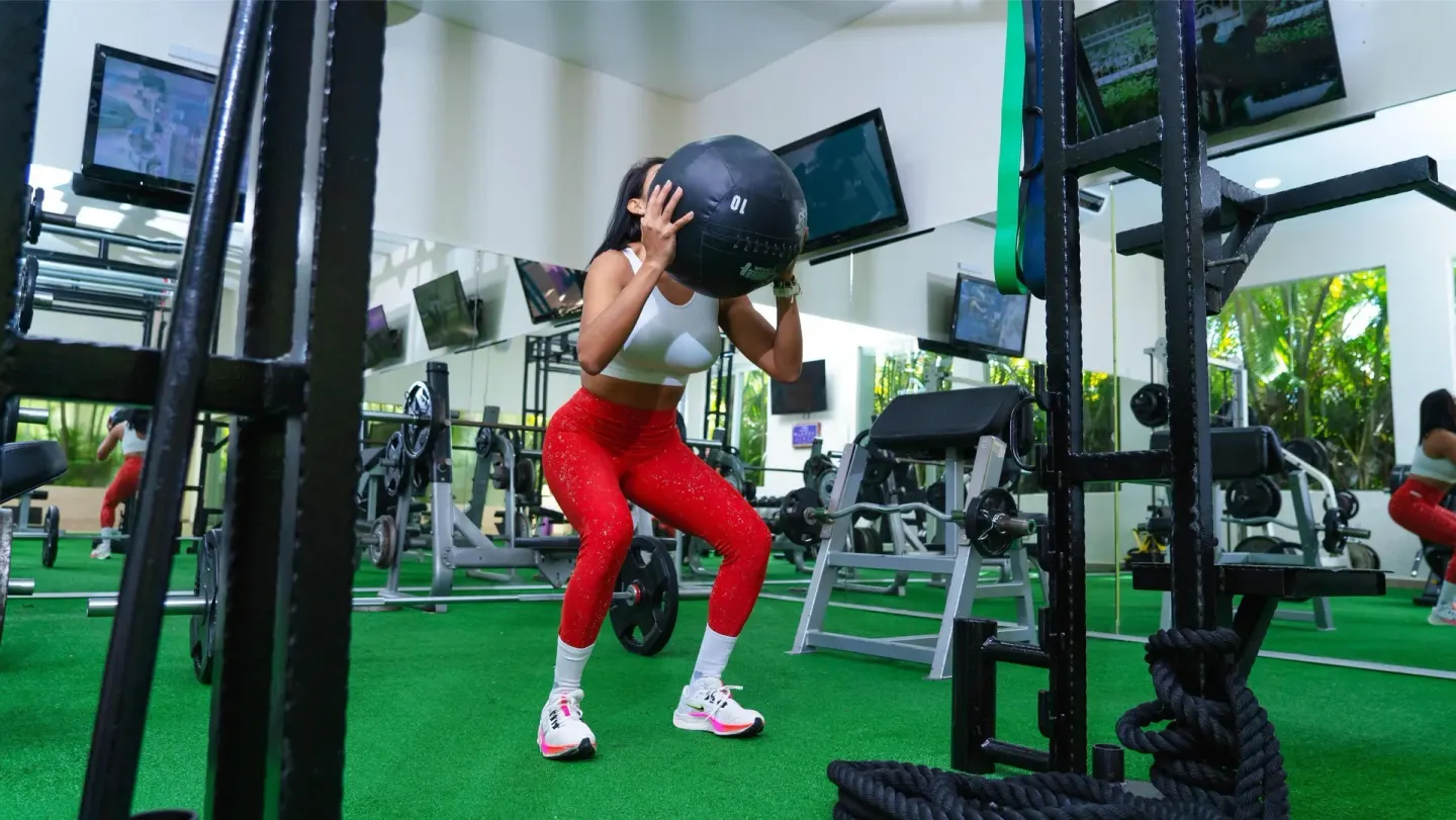 Guest exercises with a medicine ball in the fitness center at Oasis Palm.
